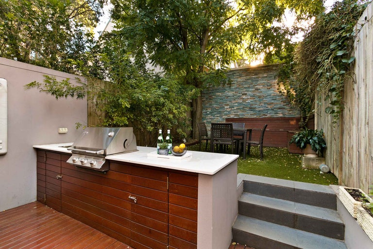 Garten mit Grill, Gartentisch und Stühlen