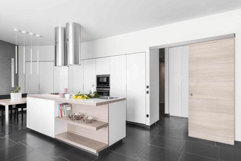 Helle Küche mit Kochinsel, Dunstabzugshaube und Schiebetür