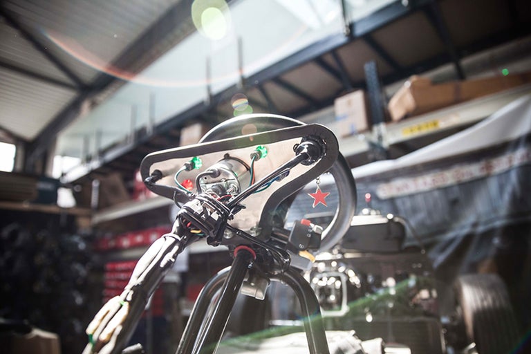 Detailansicht des Lenkers mit Kabeln und Bedienelementen im Werkstattbereich