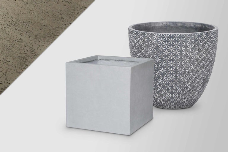 Zwei Pflanzgefäße aus Zement: ein quadratischer und ein runder Topf mit Muster