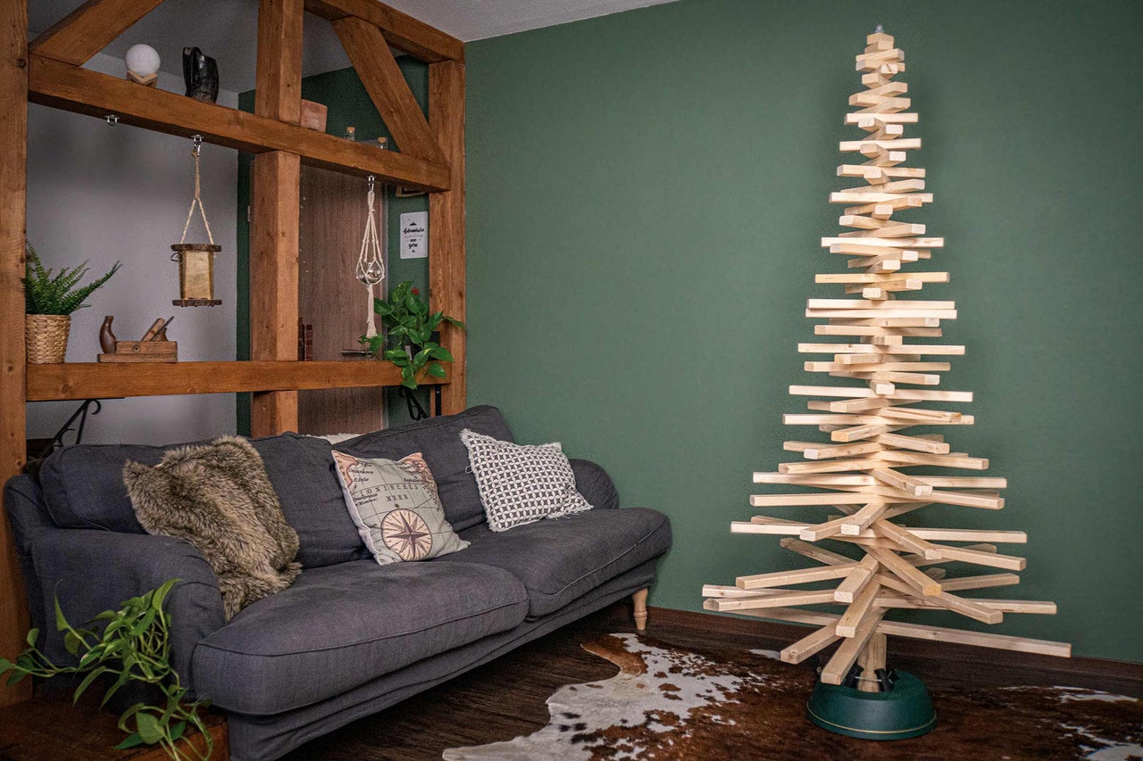 Dekoratives Wohnzimmer mit Sofa und hölzernem Tannenbaum