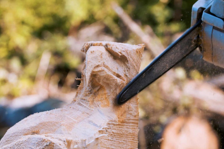 Holzskulptur wird mit einer Kettensäge bearbeitet.