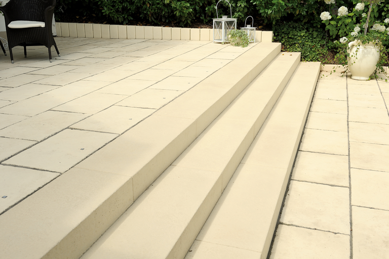 Terrasse mit Steinstufen, Sitzgelegenheit und Pflanzen