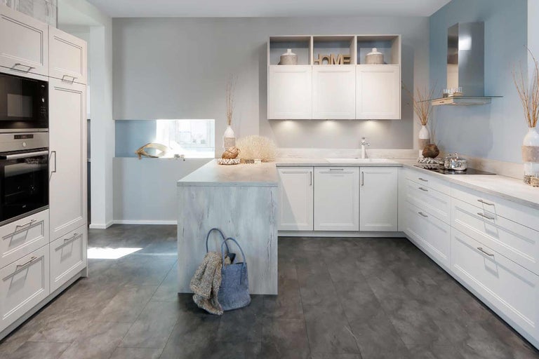 Helle Küche mit weißen Schränken, Kücheninsel und modernen Geräten.