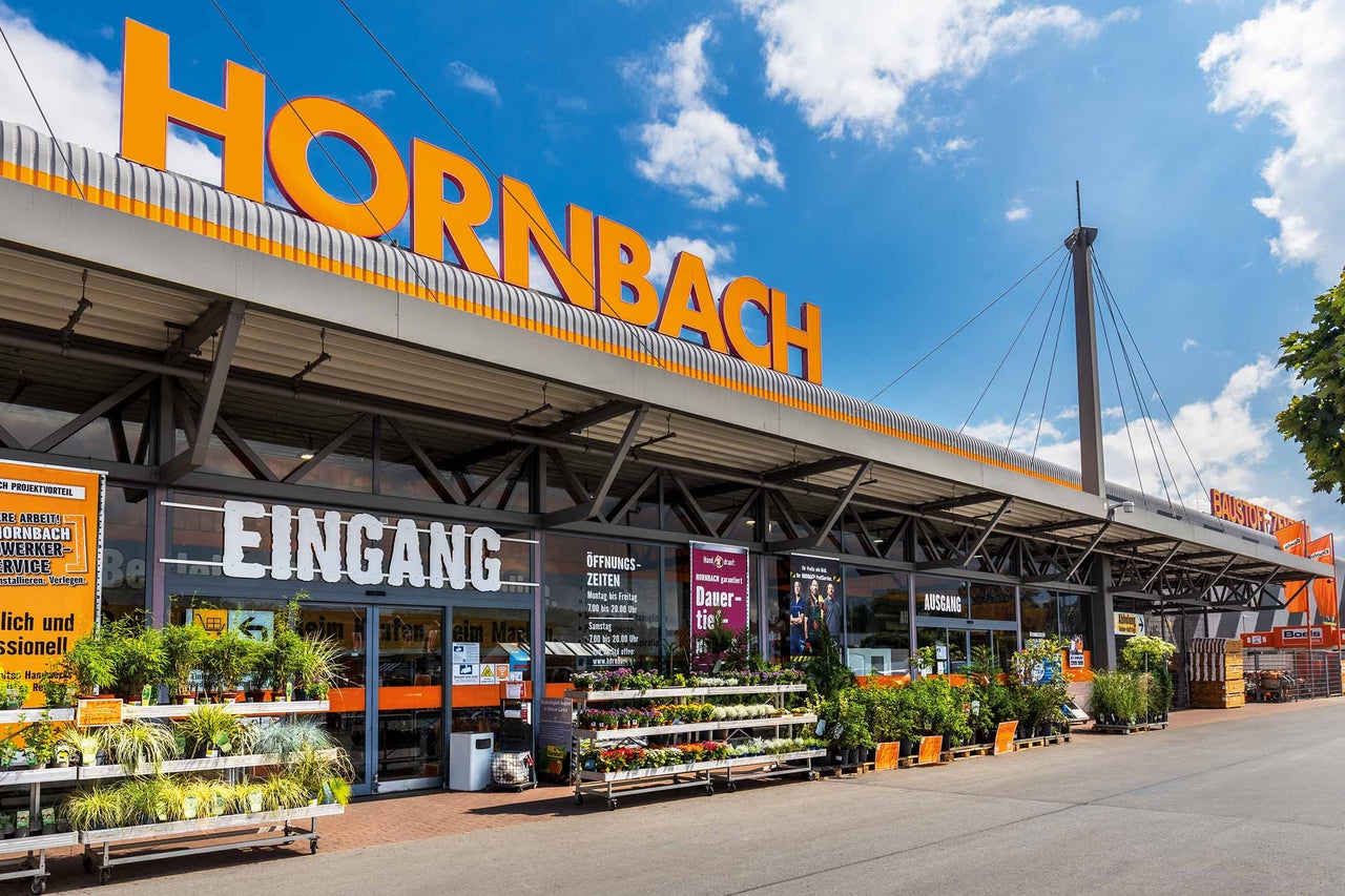 Außenansicht eines Hornbach Baumarktes mit Eingang und Pflanzen im Außenbereich 
