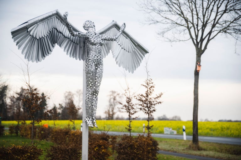 Skulptur einer geflügelten Frau aus Metall im Außenbereich
