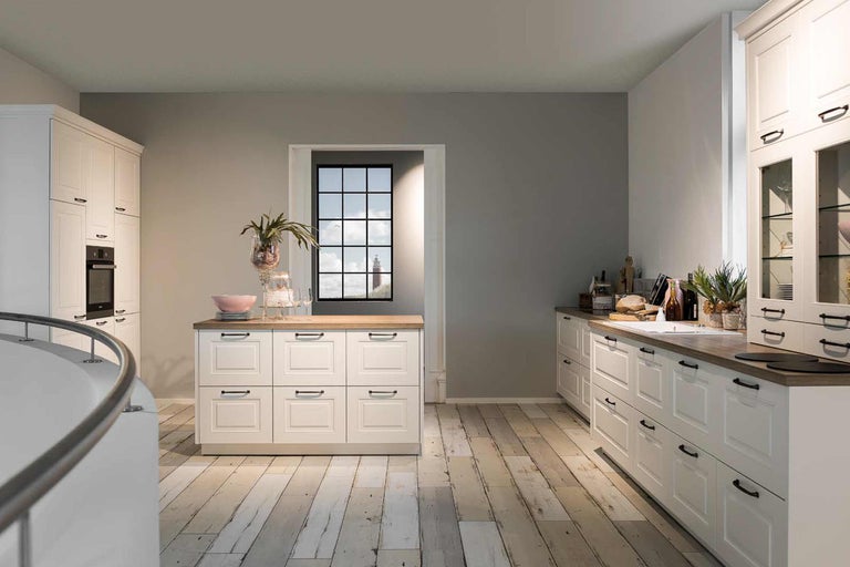 Helle Küche mit weißen Schränken, Holzboden und einem Fenster mit Blick auf einen Leuchtturm