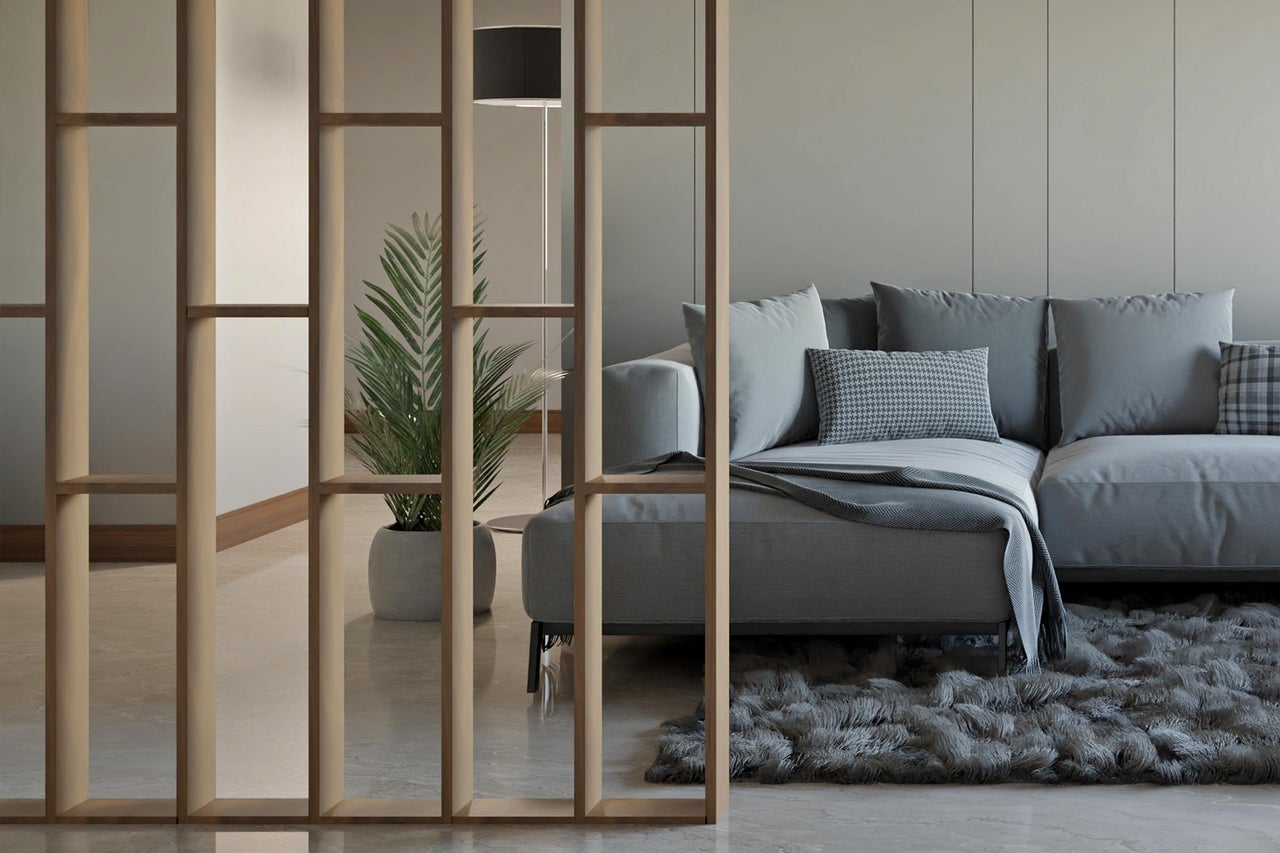 Wohnzimmer mit Sofa, Teppich und Raumteiler