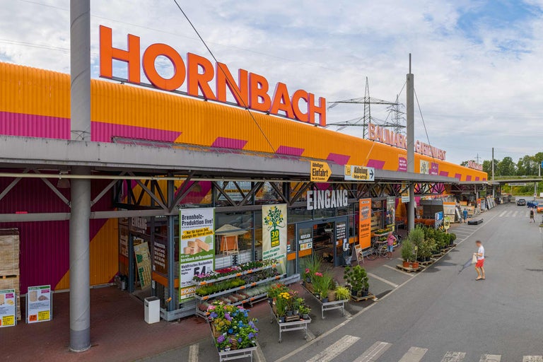 Aussenansicht eines Hornbach Baumarktes mit Eingangsbereich und Pflanzenverkauf.
