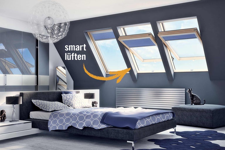 Schlafzimmer mit Dachfenstern, Bett und Heizkörper zur intelligenten Belüftung