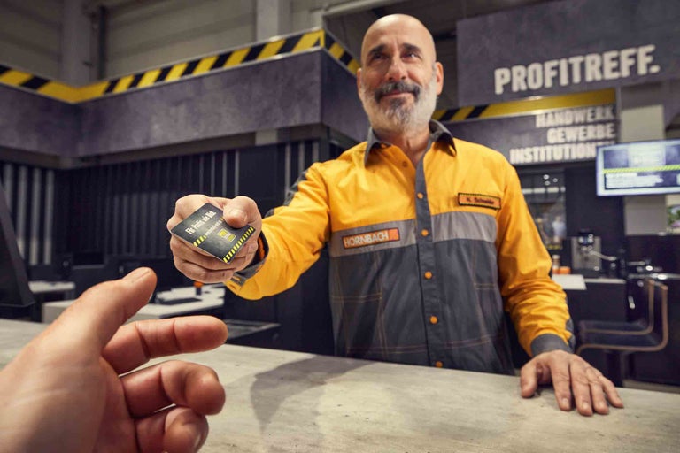 Ein Hornbach Mitarbeiter reicht eine Kundenkarte über einen Tresen.