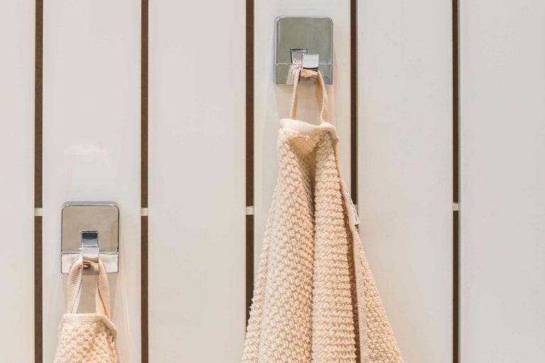 Handtücher an verchromten Haken an einer Wand