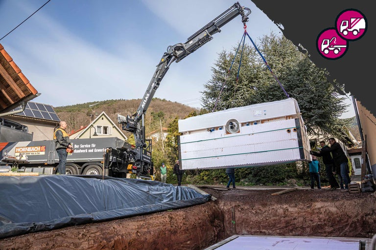 Kran hebt Keller von Hornbach in Baugrube