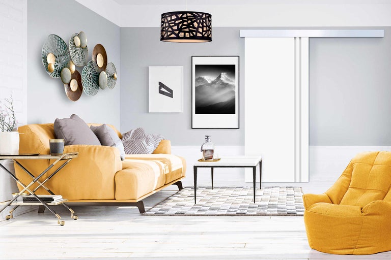 Wohnzimmer mit Sofa, Sessel, Couchtisch und Wanddekoration