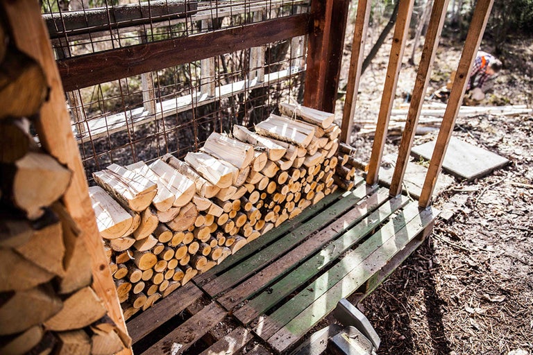 Gestapeltes Brennholz im Holzregal für den Aussenbereich.