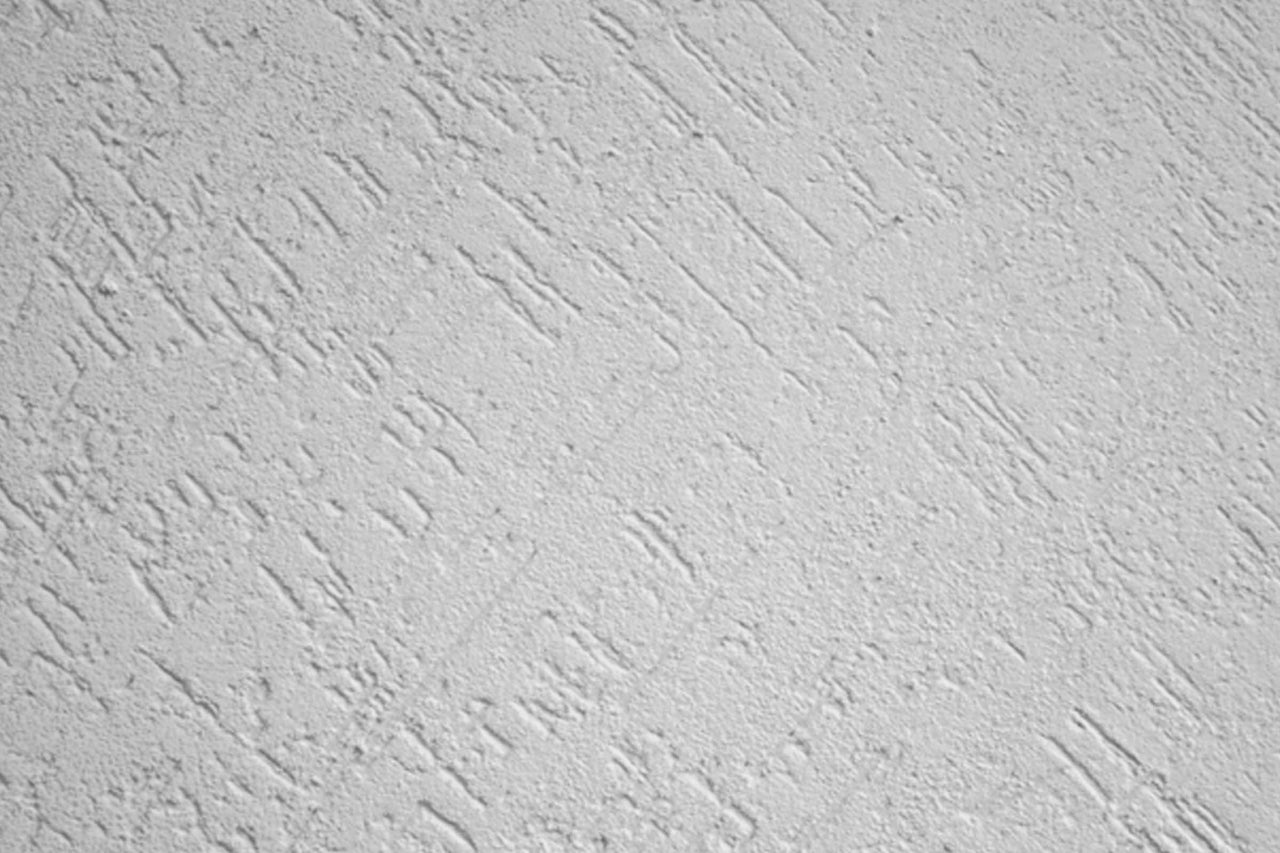 Nahaufnahme einer Wand mit Kratzputzstruktur.