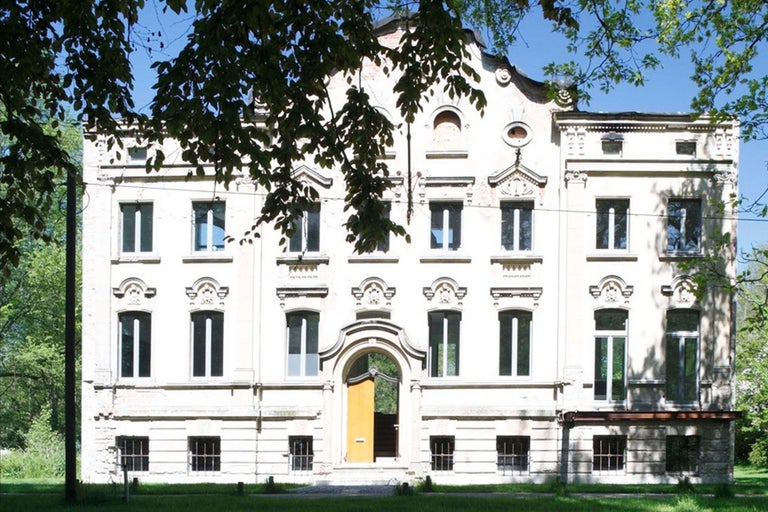 Fassade eines mehrstöckigen Gebäudes mit Fenstern und Eingang