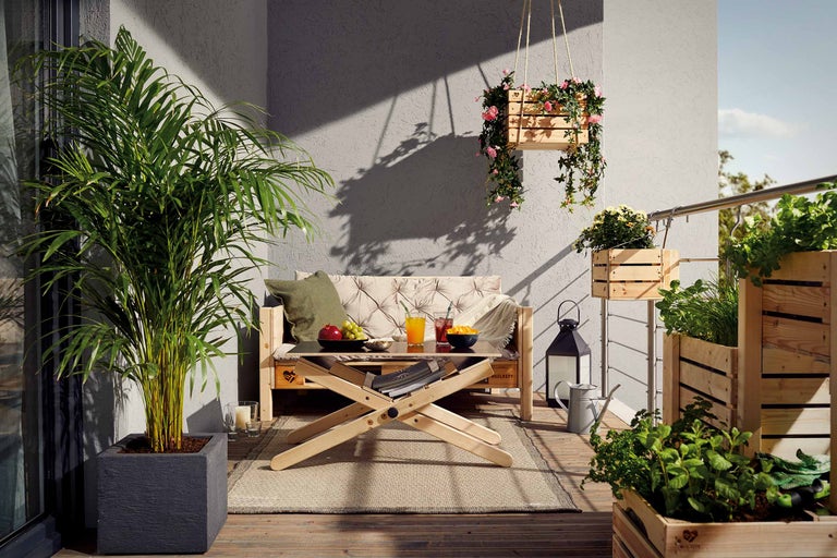 Dekorierter Balkon mit Holzmöbeln und Pflanzen in Pflanzgefäßen