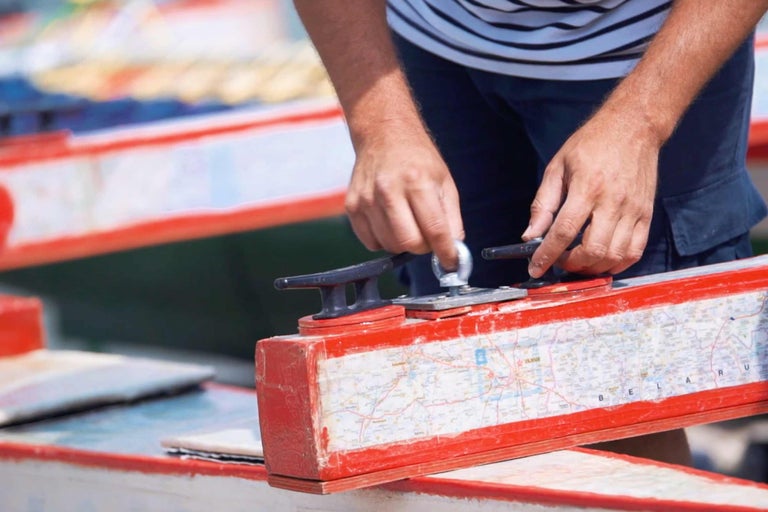 Mann befestigt eine Bootsklampe an einem Boot mit Karte