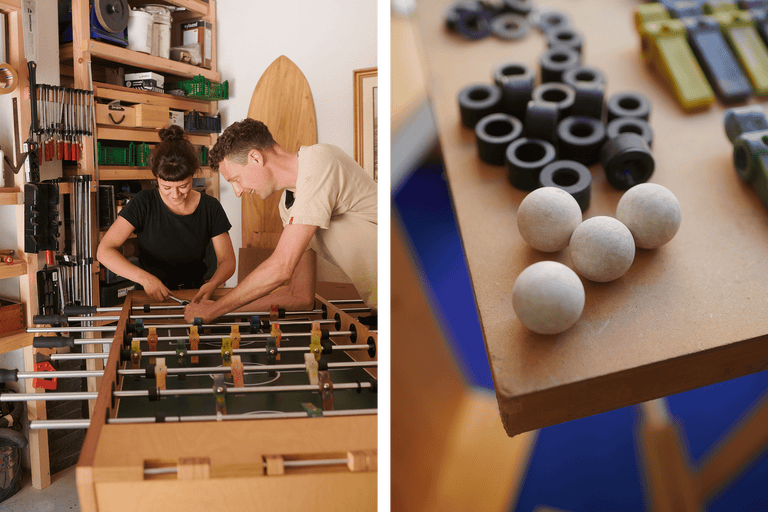 Zwei Personen reparieren einen Tischfußball in einem Hobbyraum; Ersatzteile liegen bereit.