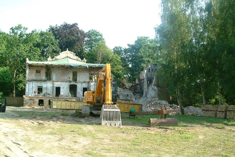 Abbruchhaus mit Bagger auf einer Baustelle