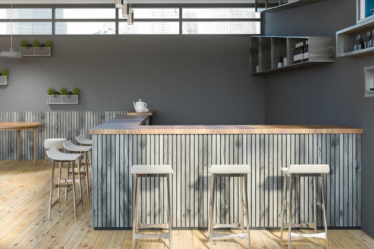 Innenaufnahme einer Bar mit Holzelementen und Barhockern