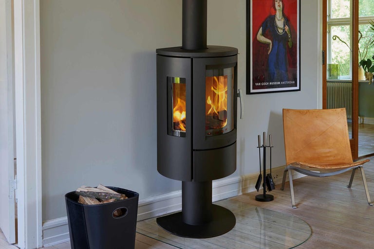 Kaminofen mit Holzscheiten und Kaminbesteck in einem Wohnraum