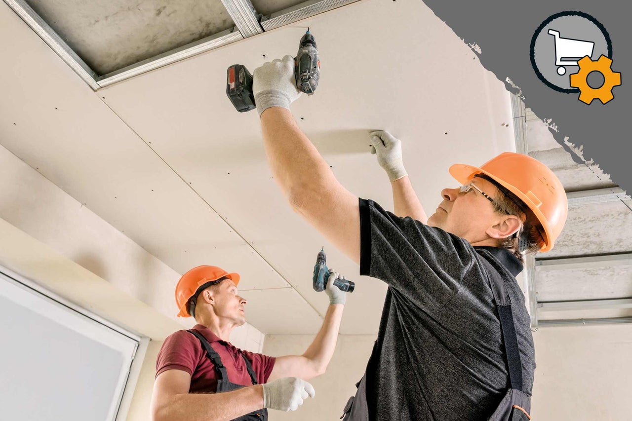 Zwei Bauarbeiter montieren eine Gipskartondecke mit einem Akkubohrer.