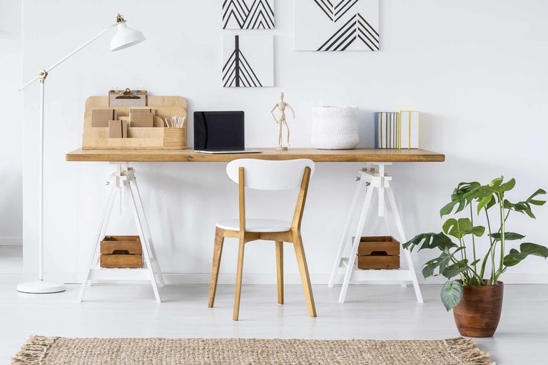 Helles Arbeitszimmer mit Schreibtisch, Stuhl, Stehlampe und Zimmerpflanze