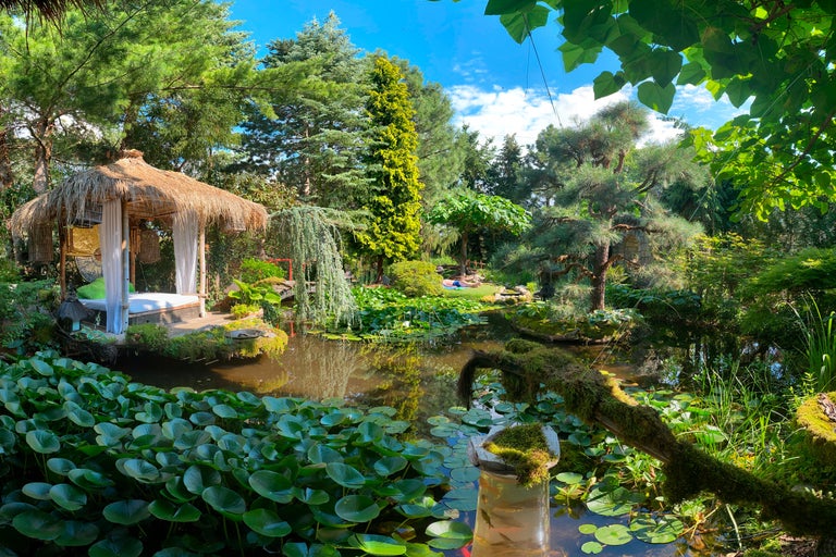Gartenlandschaft mit Teich, Seerosen und einem Pavillon mit Strohdach