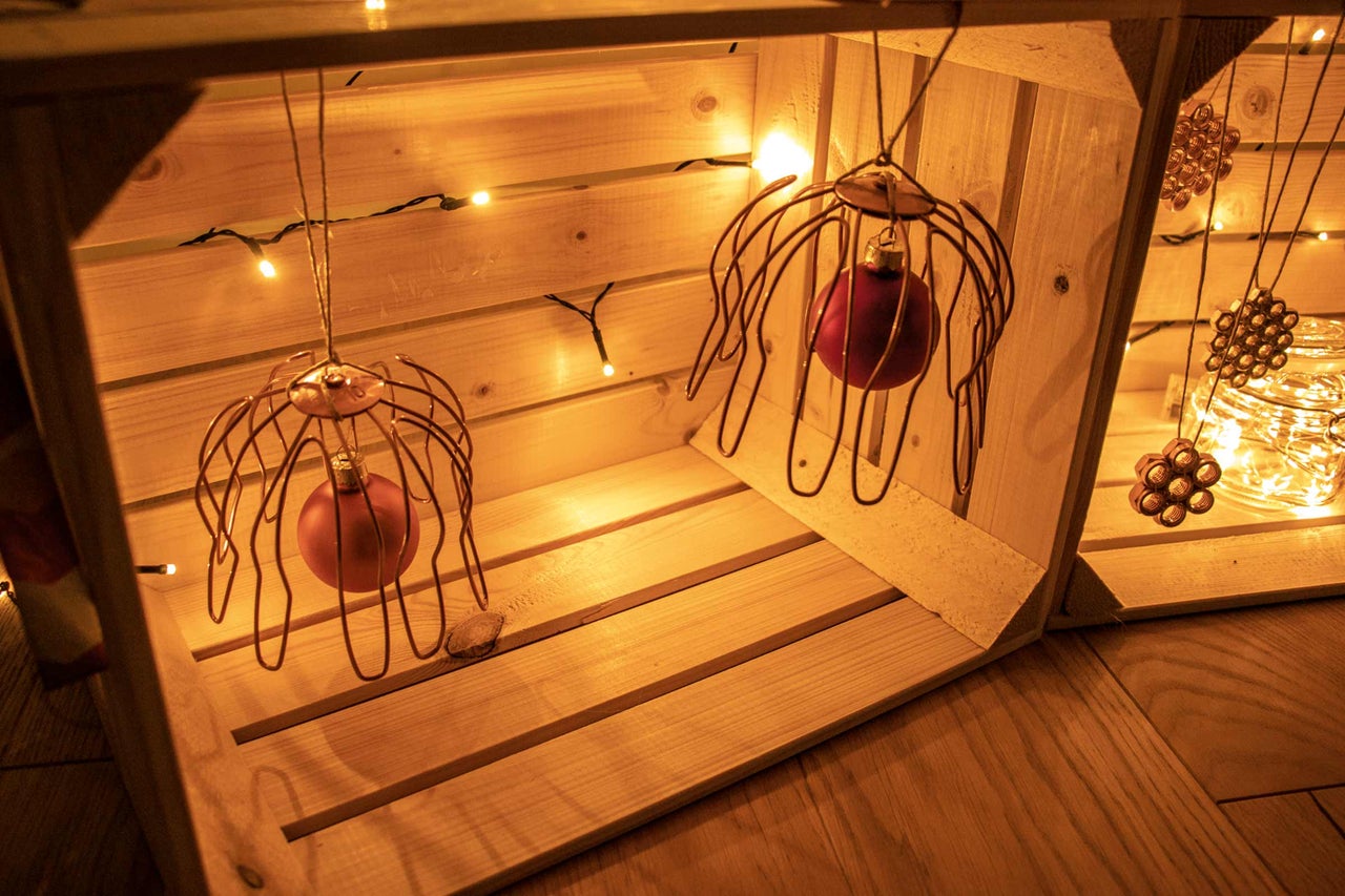 Dekorative Holzkiste mit Weihnachtsbaumkugeln und Lichterkette für eine festliche Atmosphäre