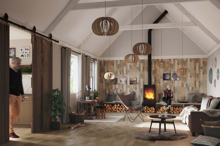 Gemütliches Wohnzimmer im Landhausstil mit Kamin, Holzvertäfelung, Pendelleuchten und Schiebetür