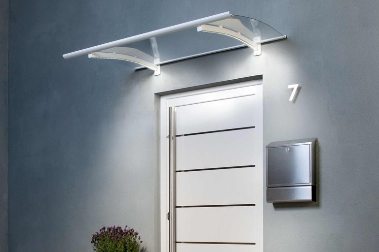 Vordach mit Beleuchtung über einer Haustür mit Briefkasten und Hausnummer.