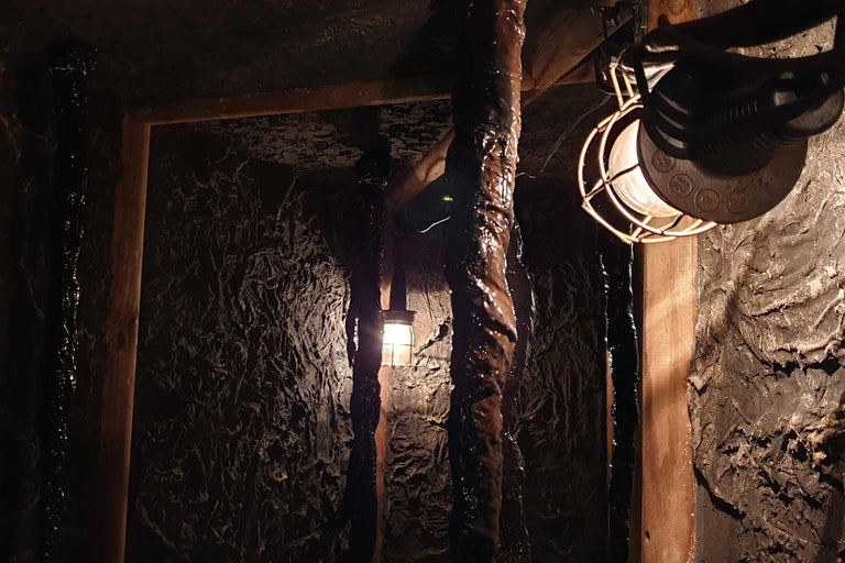 Beleuchteter Minenschacht mit Holzbalken und Lampe