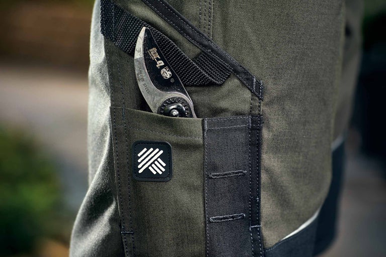 Detailaufnahme einer Arbeitshose mit einer Gartenschere in der Tasche
