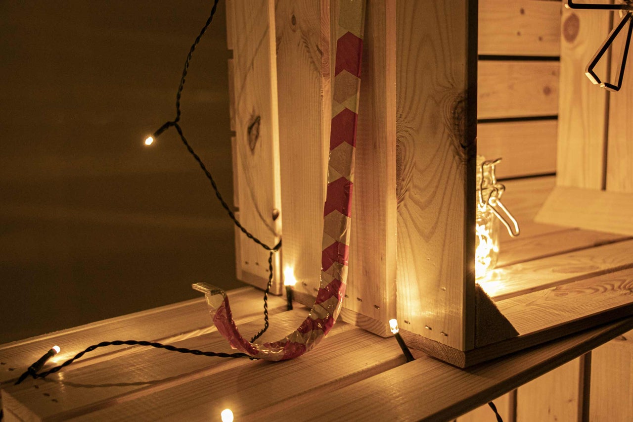Holzregal mit Dekoration, Lichterkette und einer Dekoration mit rotem Muster