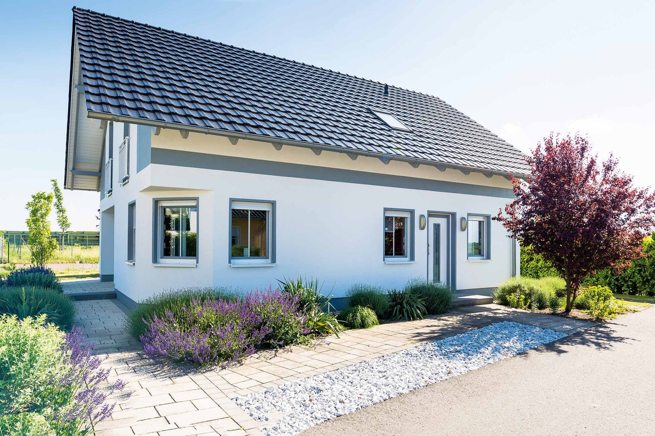 Einfamilienhaus mit Satteldach, Fenstern und gepflastertem Weg