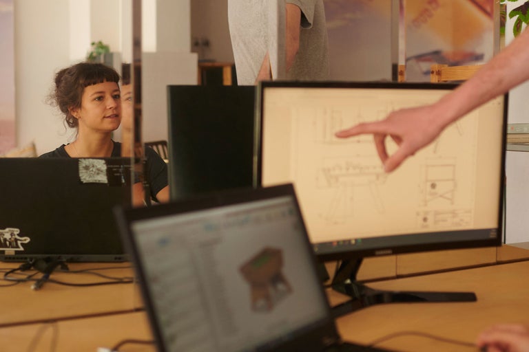 Personen arbeiten an Computern mit technischer Zeichnung am Bildschirm