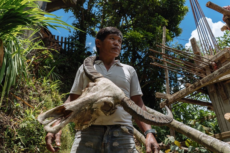 Mann mit Tier Schädel im Freien vor Baustelle