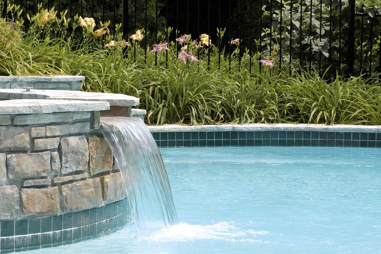 Schwimmbad mit Wasserfall und Steinmauer