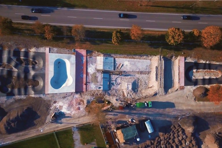 Luftaufnahme einer im Bau befindlichen Skateanlage neben einer Autobahn