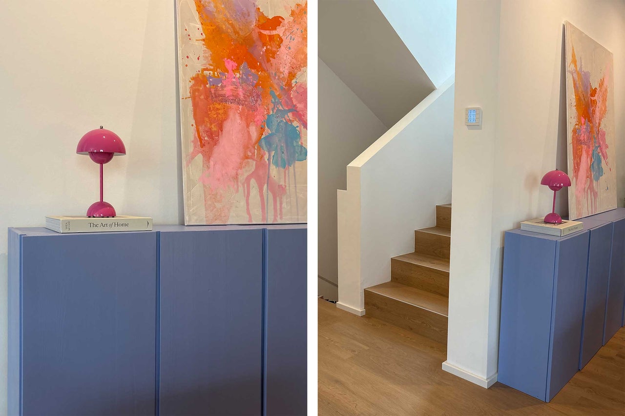 Heller Flur mit blauen Schränken, einem Kunstwerk und einer Treppe