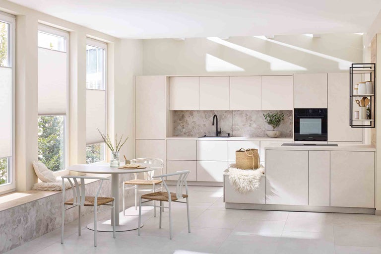 Helle Küche mit Esstisch, Stühlen und Einbauschränken für einen organisierten und geräumigen Eindruck.