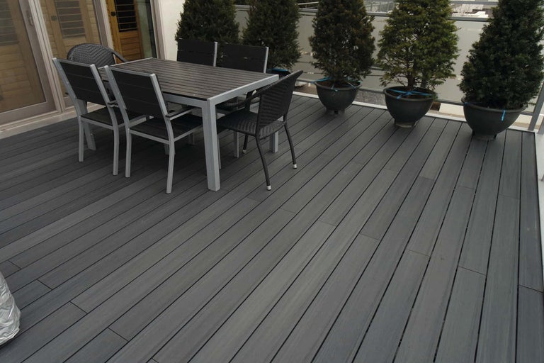 Terrasse mit Esstisch und Stühlen sowie Topfpflanzen