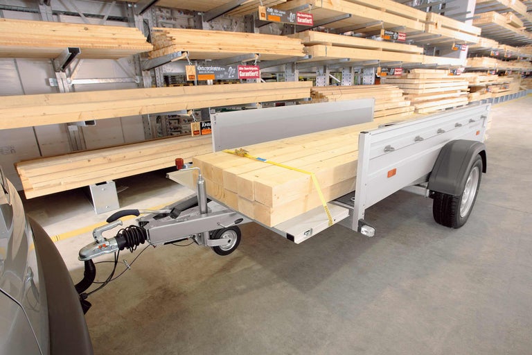 Ein beladener Anhänger mit Holzbrettern im Hornbach Baumarkt.