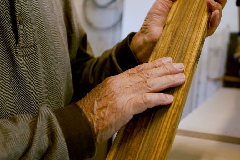 Hände halten Holzbrett