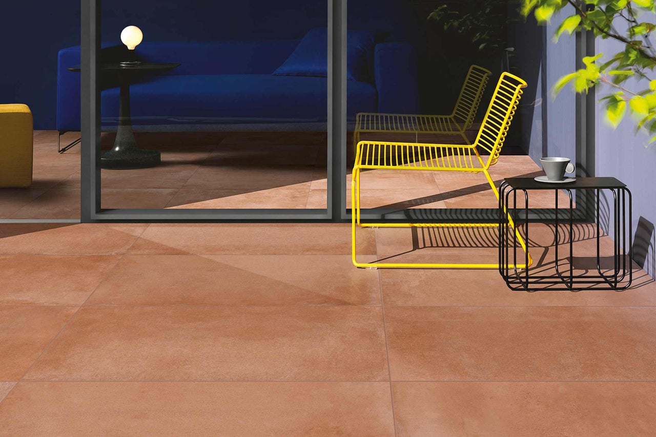 Terrasse mit Bodenfliesen, Stühlen und Tisch