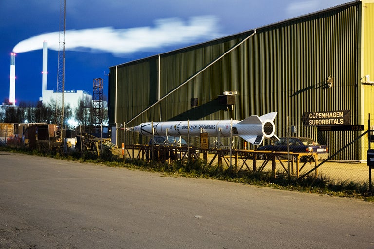 Eine Rakete steht vor einem Gebäude.