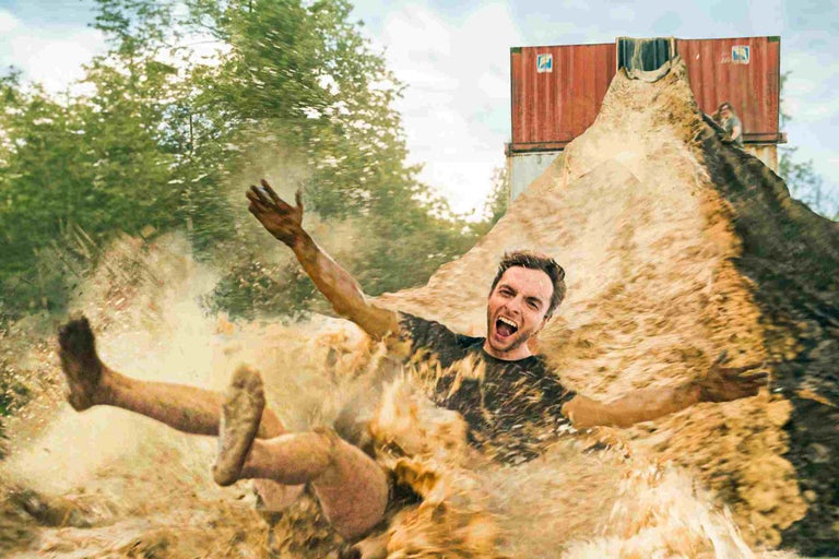 Mann rutscht einen Erdhügel herunter