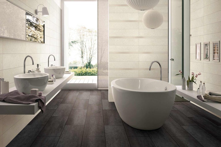 Helles Badezimmer mit Badewanne, Waschbecken und dunklen Bodenfliesen für ein modernes Design.